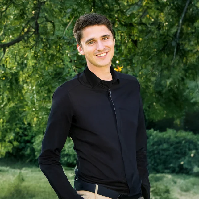 Niklas Loose Gärtnermeister bei Stockreiter GmbH. Zu sehen ist ein junger, lächelnder Mann in einem schwarzen Oberteil.