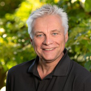 Christoph Schlarmann ein Mitarbeiter bei Stockreiter GmbH. Zu sehen ist ein junger, lächelnder Mann in einem schwarzen Oberteil.