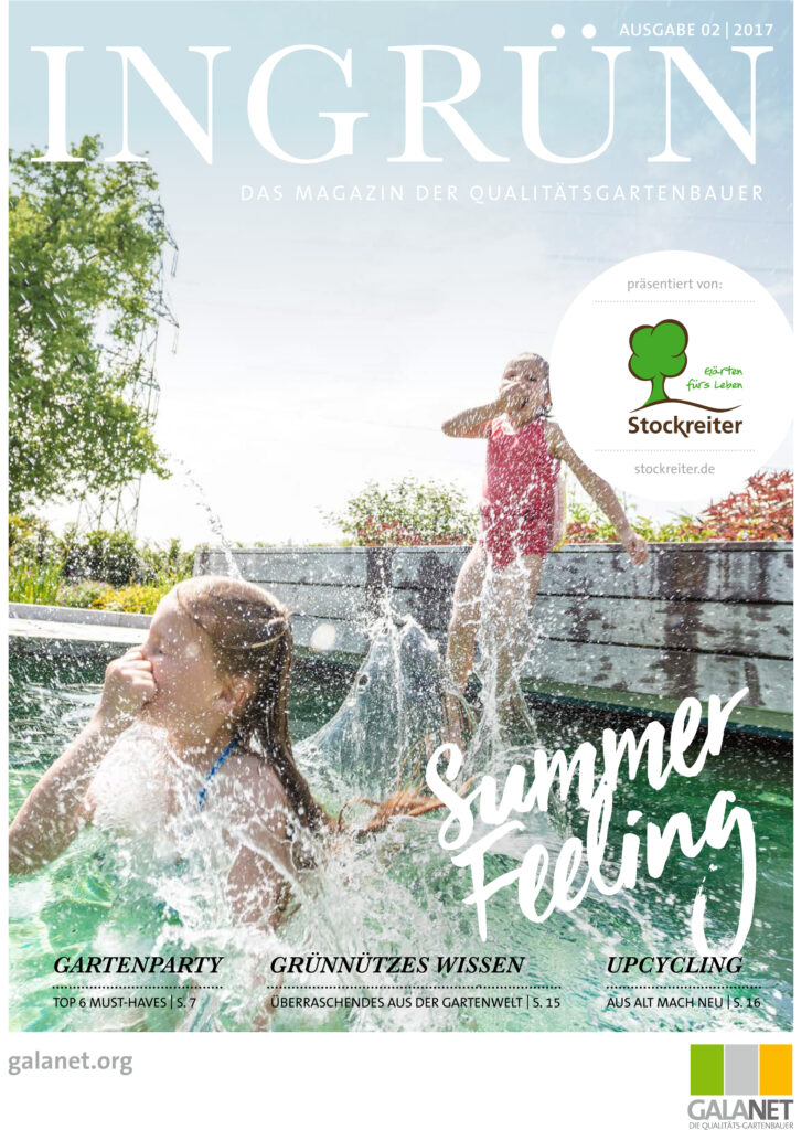 Zwei Kinder spielen fröhlich im Pool, umgeben von grünen Pflanzen, und spritzen Wasser in die Luft.