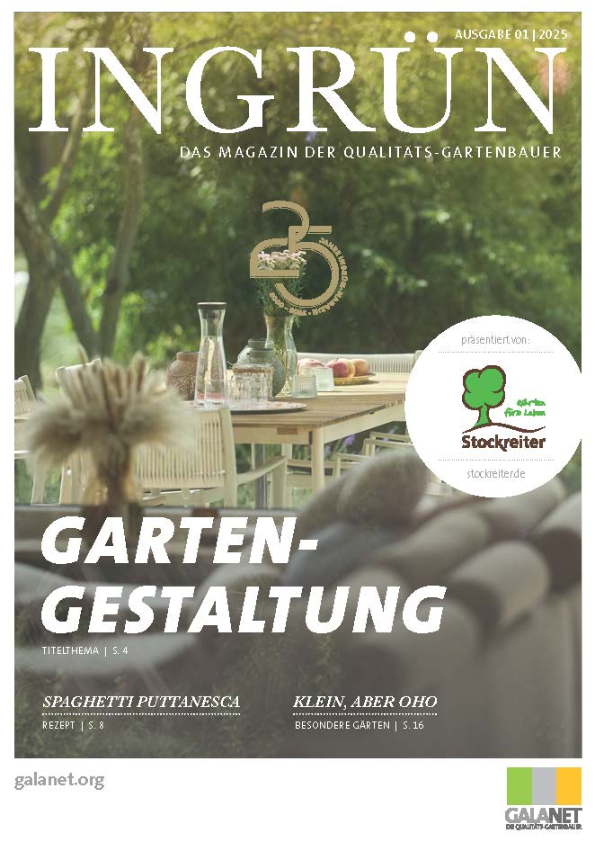 Ein Holztisch im Garten mit Gläsern, Karaffen und Blumen, umgeben von unscharfen Pflanzen im Hintergrund.