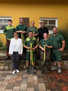 Sechs Mitarbeiter der Firma Stockreiter GmbH vor einem gelben Haus.