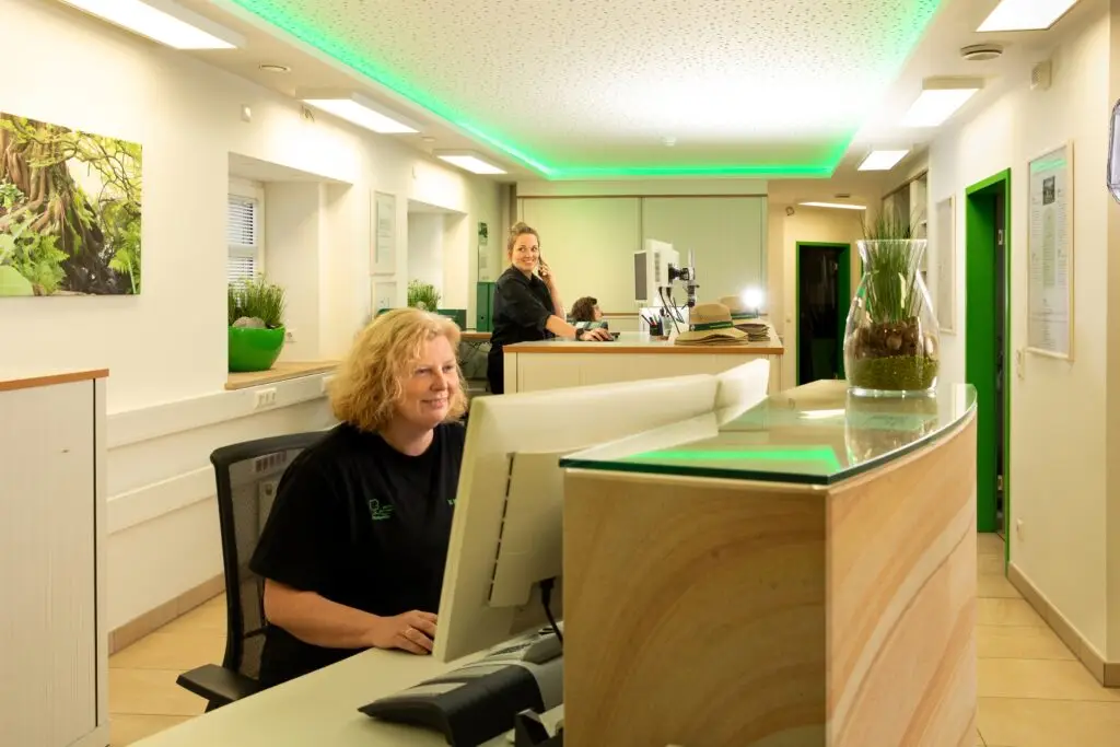 Zwei Mitarbeiter arbeiten freundlich im Empfangsbereich.