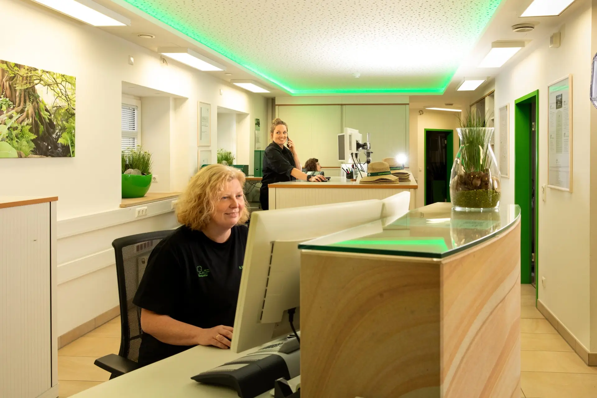 Zwei Mitarbeiter arbeiten freundlich im Empfangsbereich.