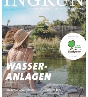 Eine Frau mit Strohhut sitzt entspannt auf einem Holzsteg vor einer Wasseranlage, umgeben von Pflanzen.